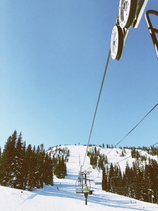 a view of the ground from below as ski lift approaches