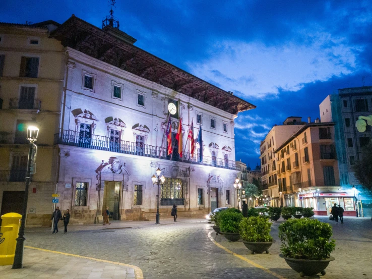 a building with lights at night on a small street