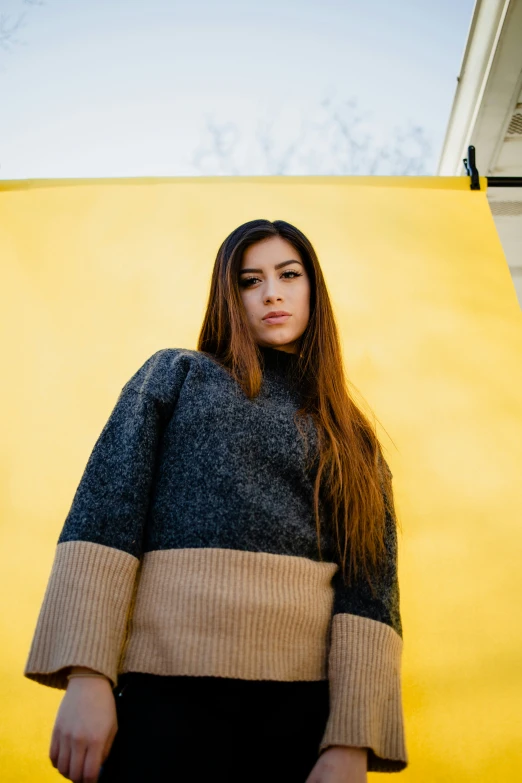 a woman standing in front of yellow background