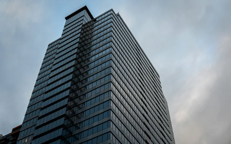 the very tall building with many windows is against a gray sky