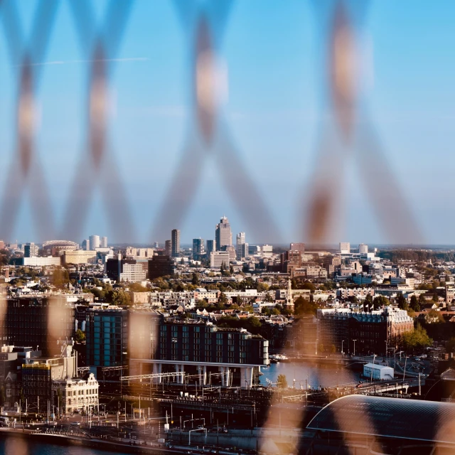 the view of a city taken through a fence