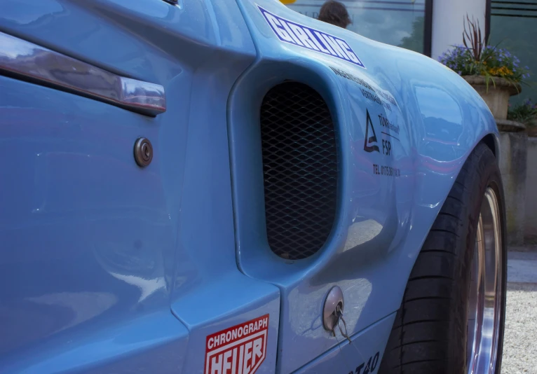 the front side of a blue race car parked outside