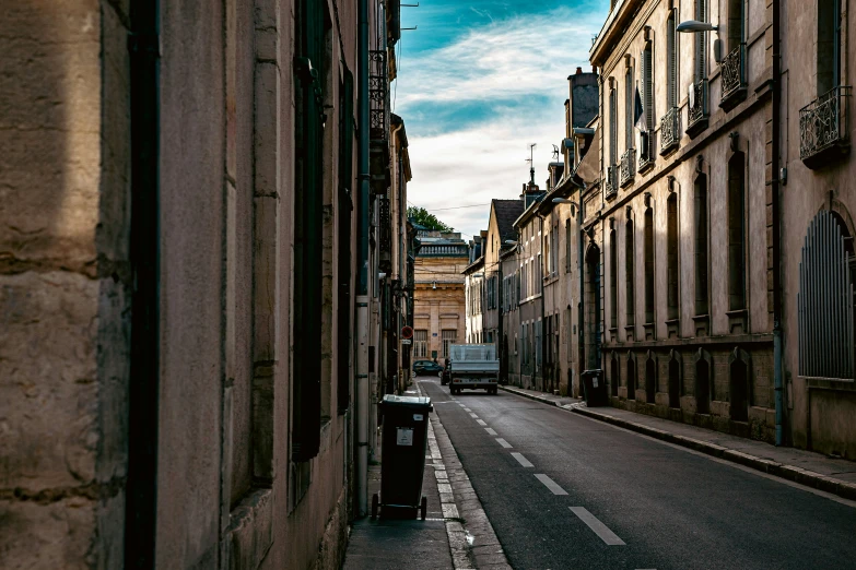 a view down a narrow city street with tall buildings