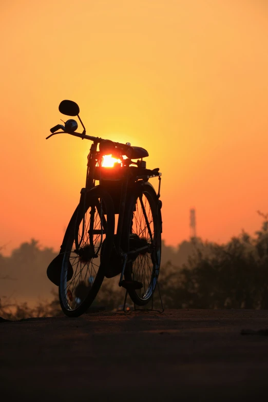 a bicycle with the sun setting in the back