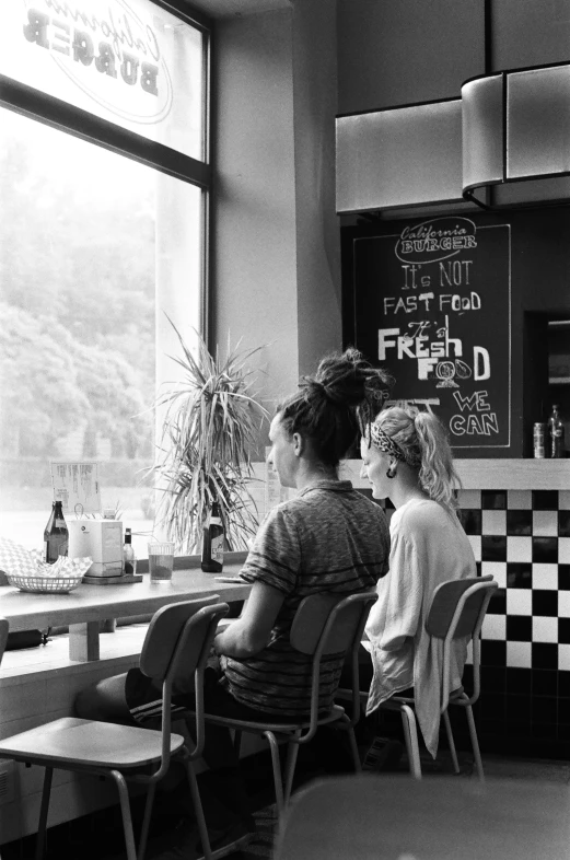 a mother and her child are sitting at a diner