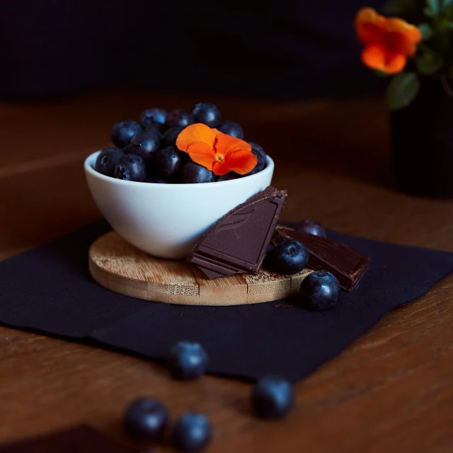 a bowl full of fruit and chocolate sitting on a table