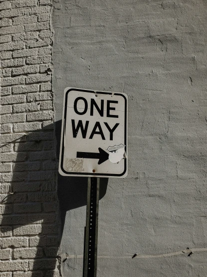 an one way sign and an arrow sign in a city