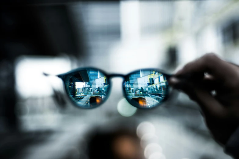 the reflection of someone wearing glasses is shown in a glass