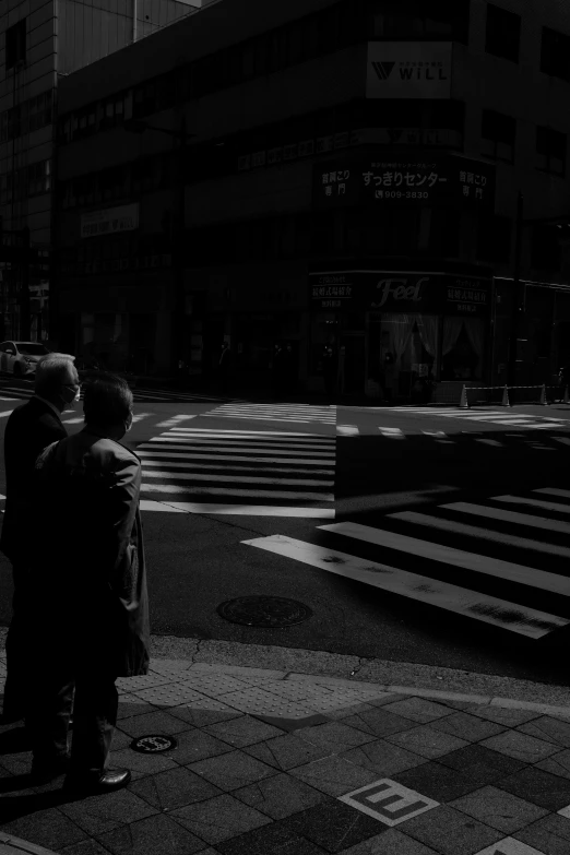 two people waiting at an empty cross walk