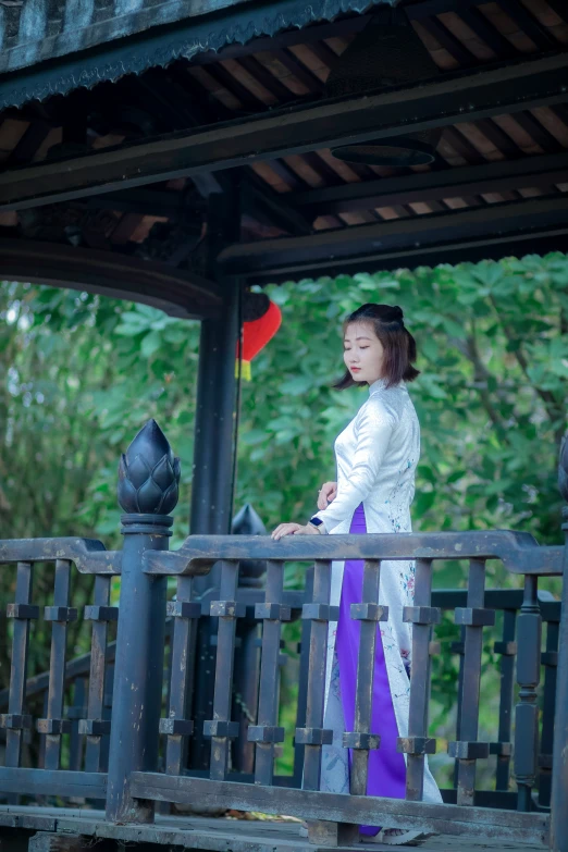 a young woman standing on top of a wooden deck