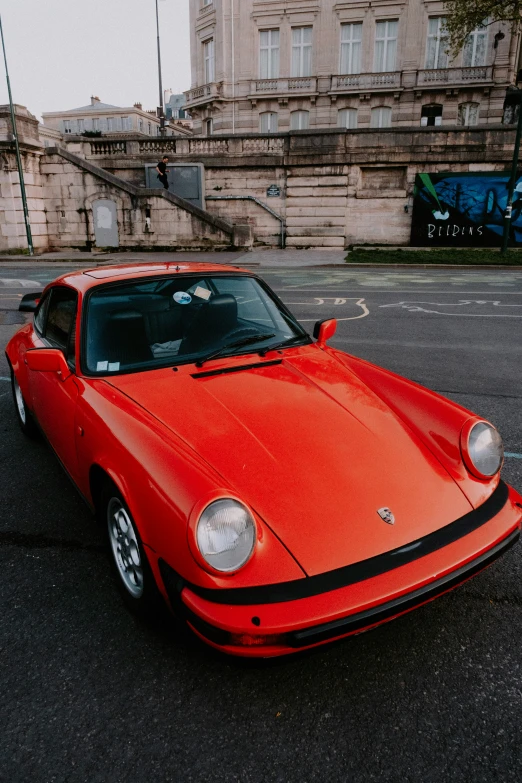 a red porsche car sitting on the side of the road