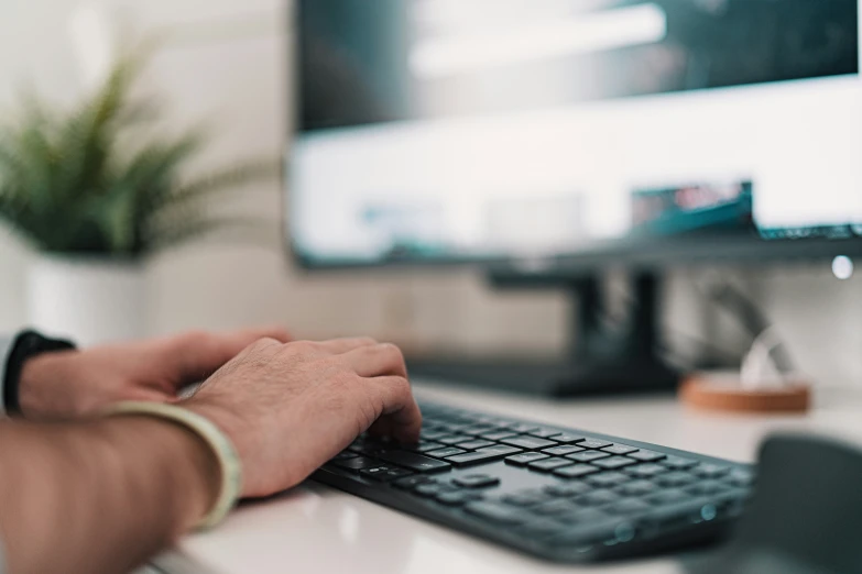 a person using a keyboard and mouse at a desk