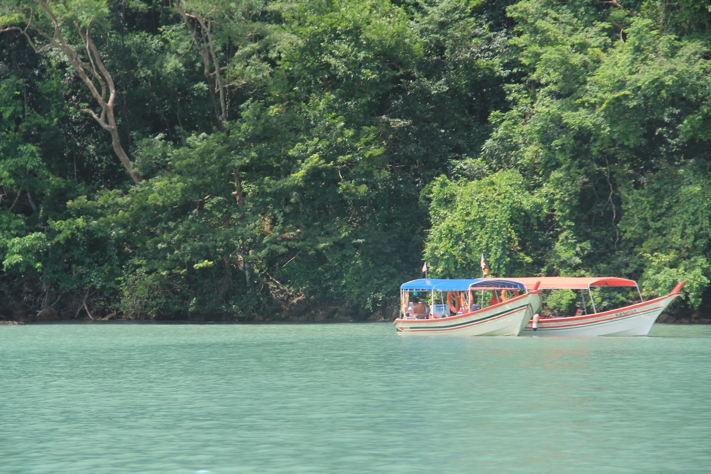 two long boats passing each other on the river