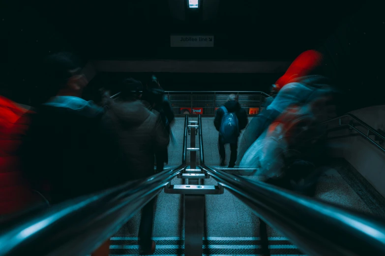 some people in motion on the subway stairs