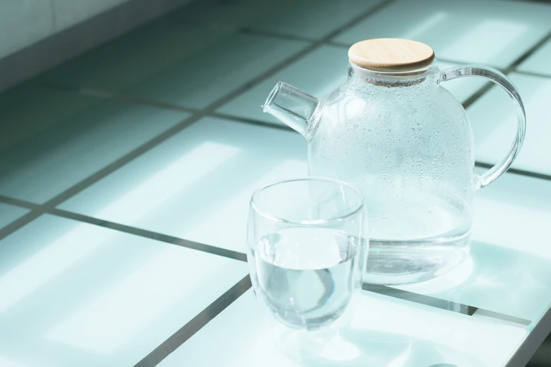 a glass and tea pot sitting on top of a table