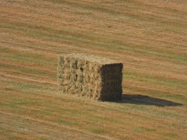 a single round bale in a field full of brown grass
