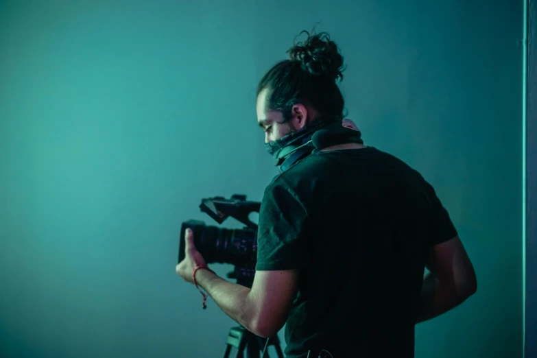 a man holding a camera and wearing an artificial headgear