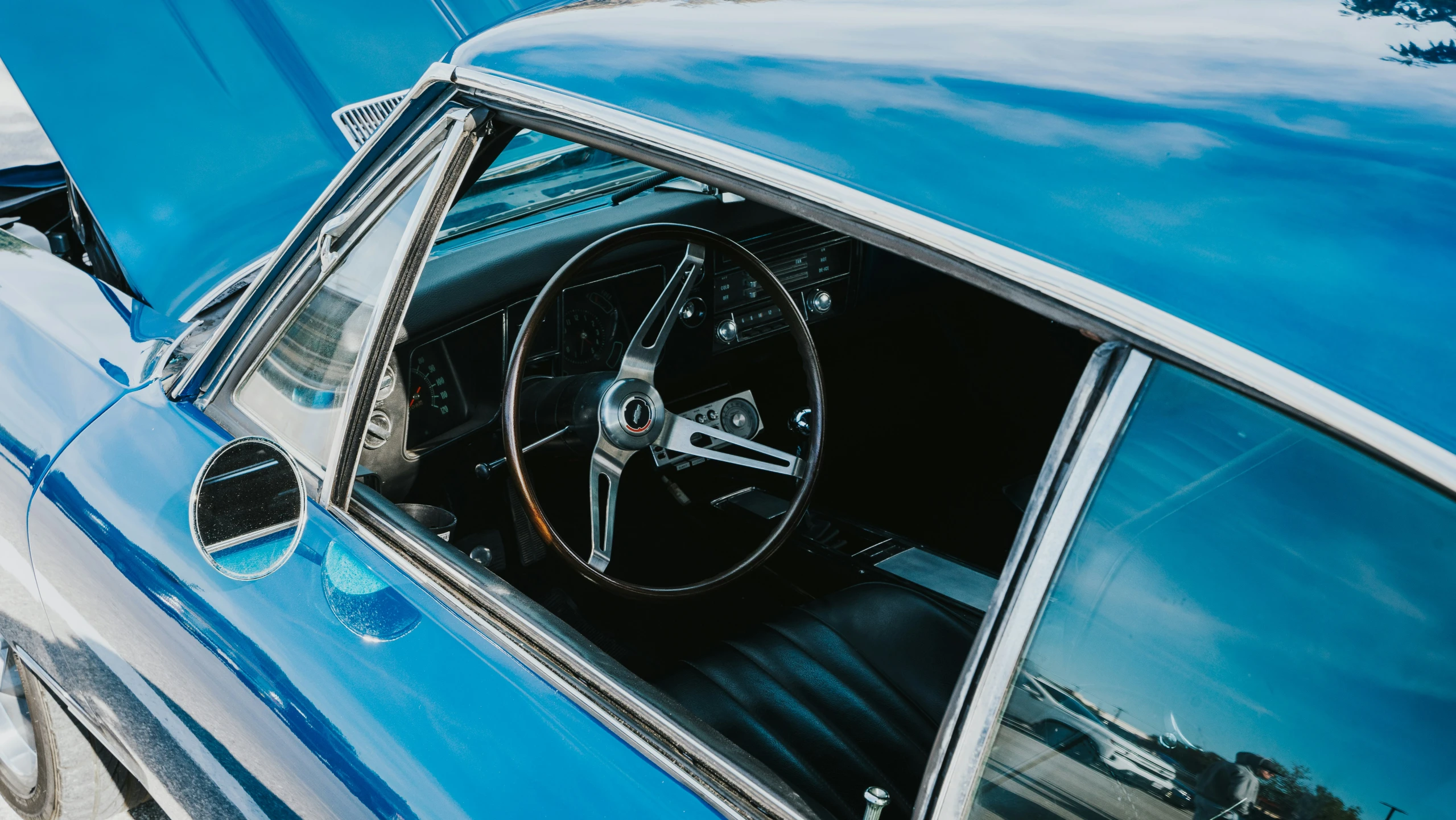 a blue muscle muscle car's interior showing the dash and steering wheel