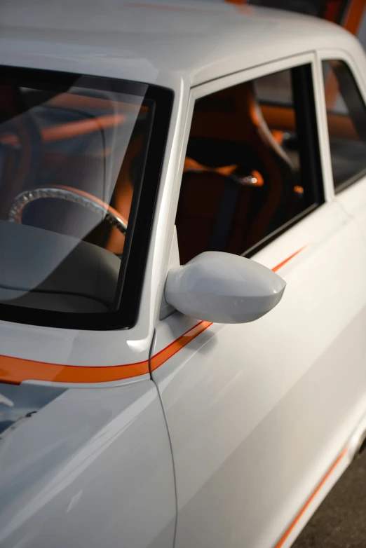 a white car parked on the street with an orange stripe