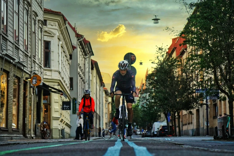 three people riding bikes in the road at sunset