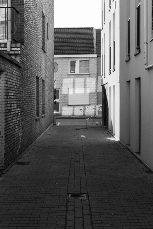 a narrow alley between two buildings in black and white