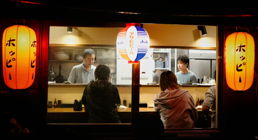 people standing in front of an asian restaurant, looking through the window