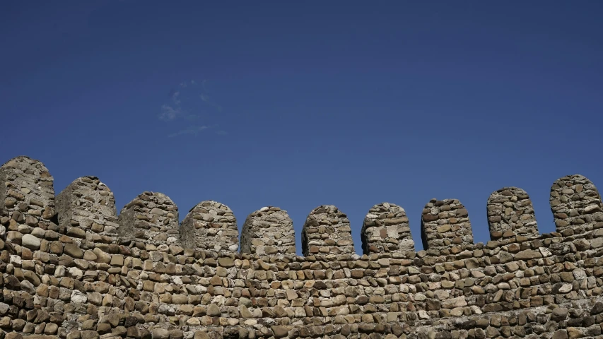 old stone wall made out of stones on top of blue sky