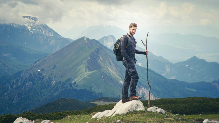 a man is standing on top of a hill with ski poles