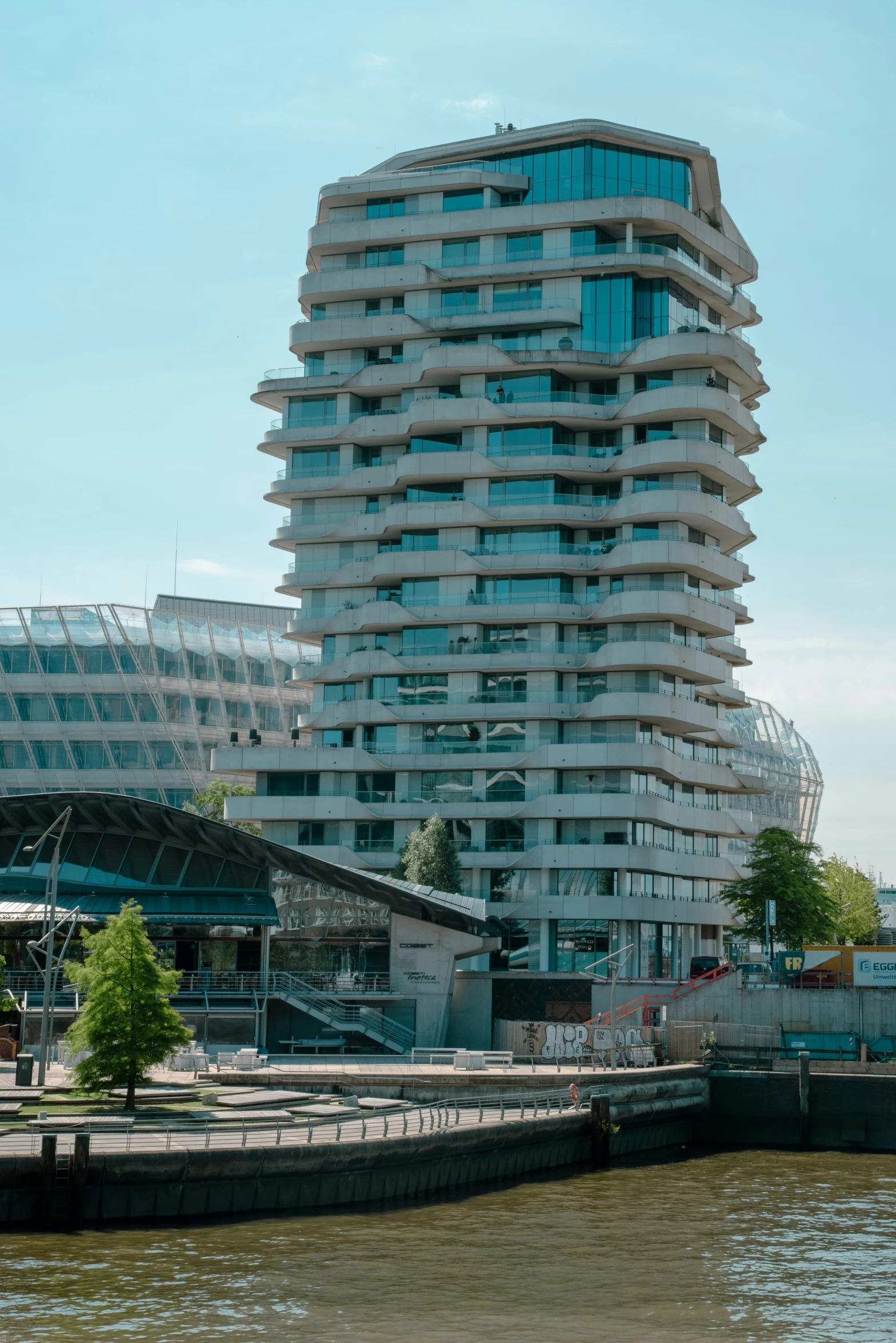 a tall white building next to the ocean