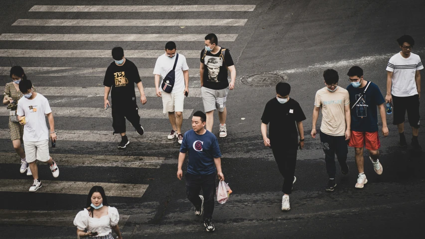 a group of young men walking across a cross walk