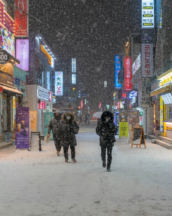 people walking in the snow near buildings