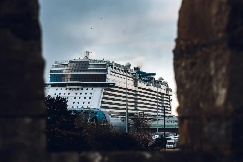 a large cruise ship on the ocean behind a building