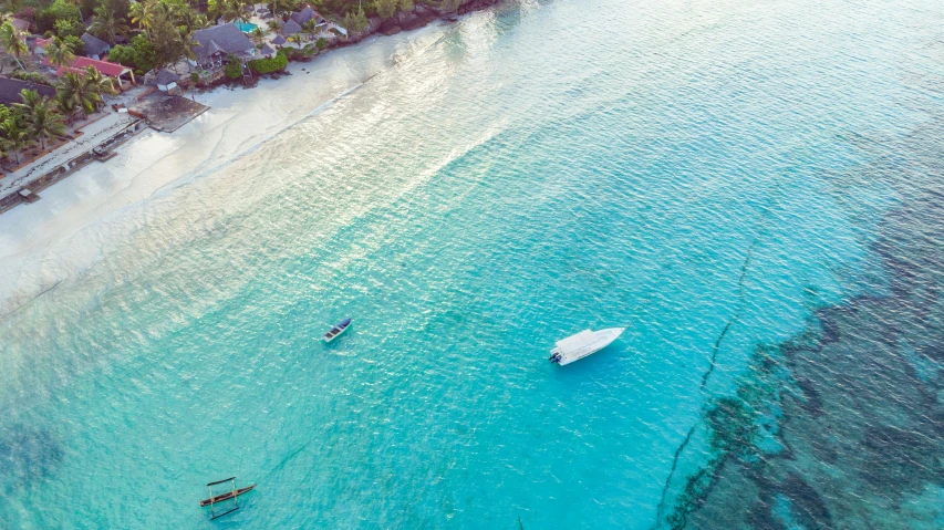 a small white boat that is sitting in the ocean