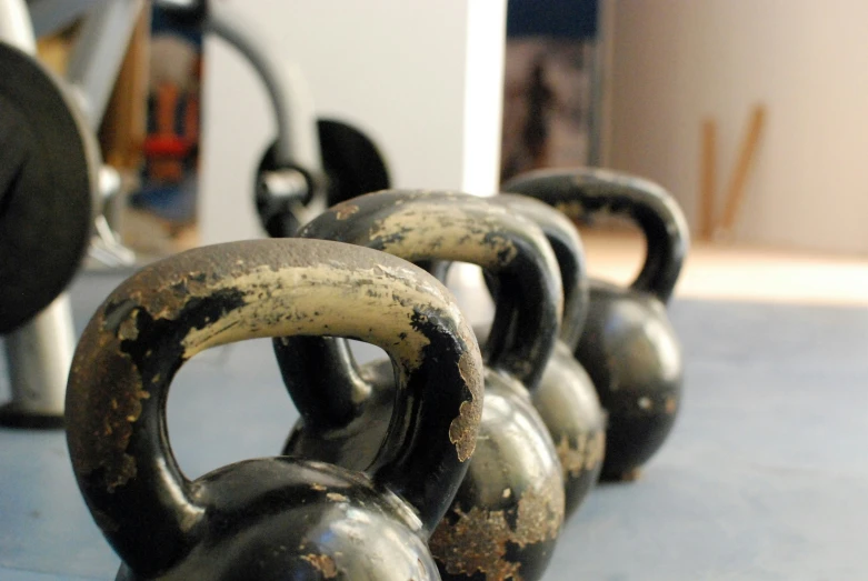 a collection of black kettles on a blue floor