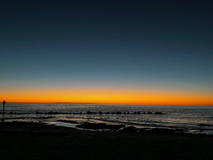 two surfers on the beach at dusk