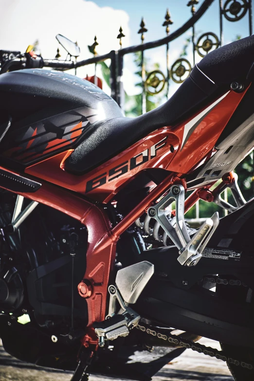 the motorcycle is parked along the curb in front of a gate