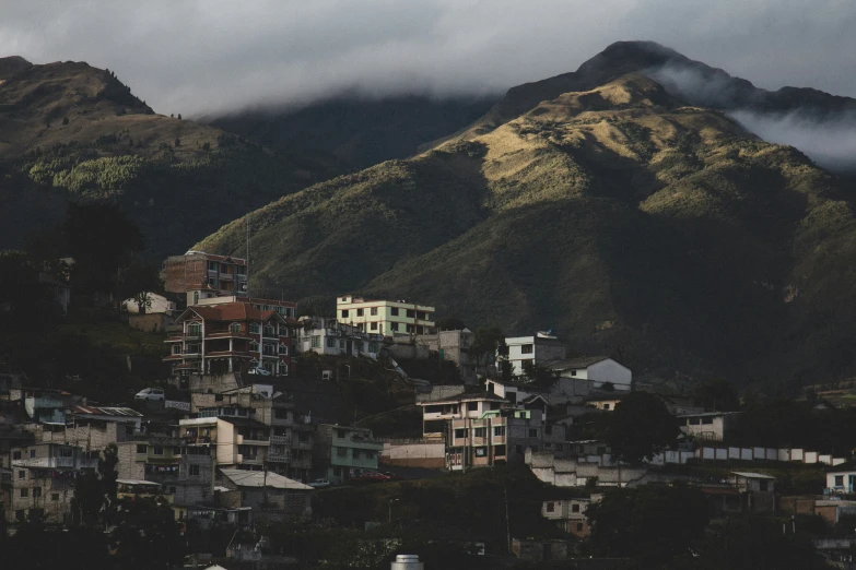 a picture of some buildings below a mountain range