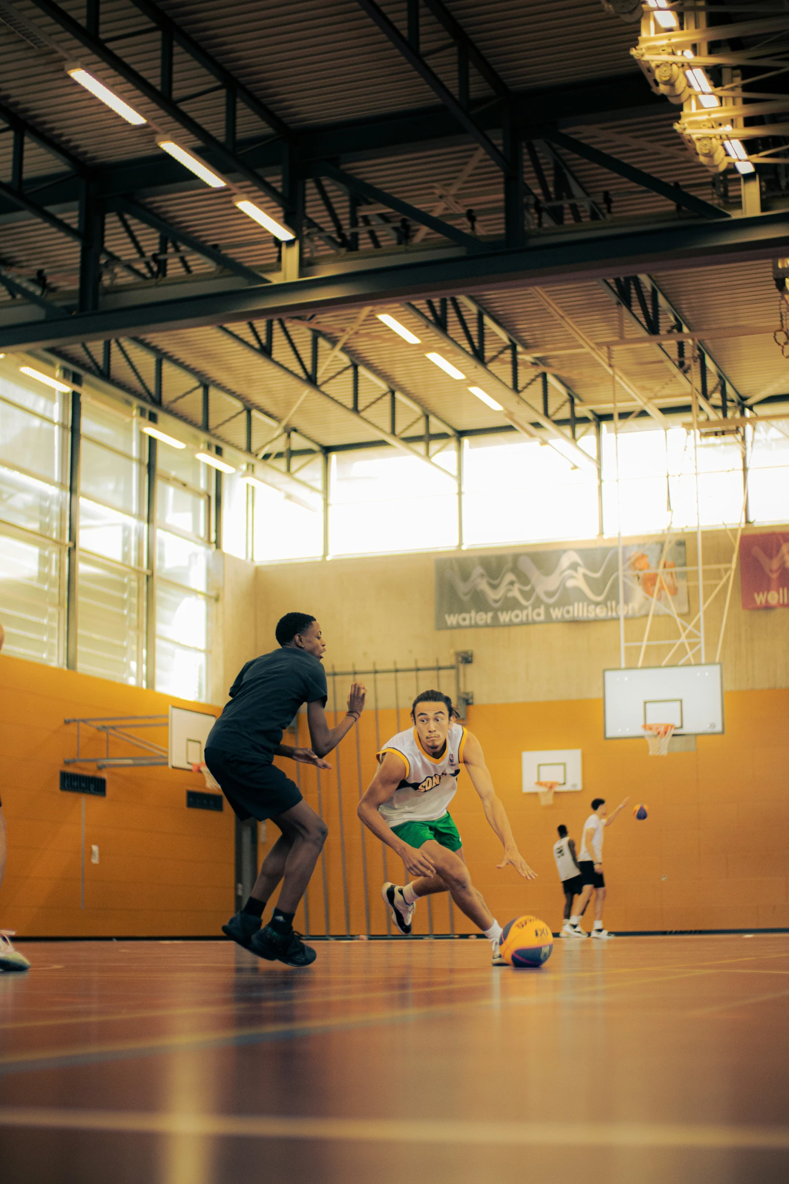 men and women playing with a soccer ball inside a basketball court