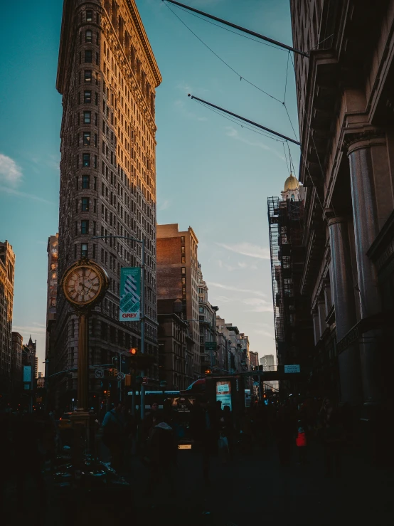 an old building in a big city with a clock on the corner