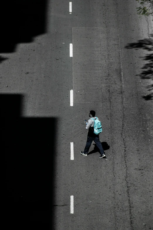 the person is walking down the street with a bag