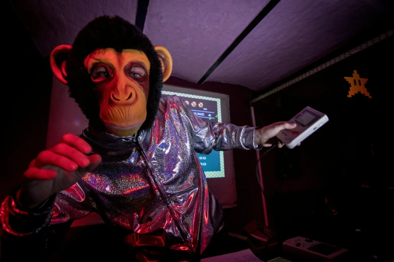 a monkey holding a remote next to a computer