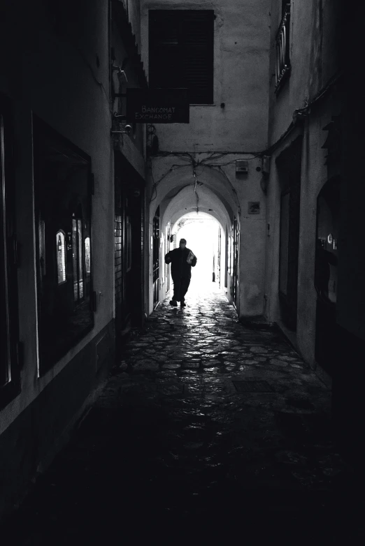 a person walking in a long, dark alley way