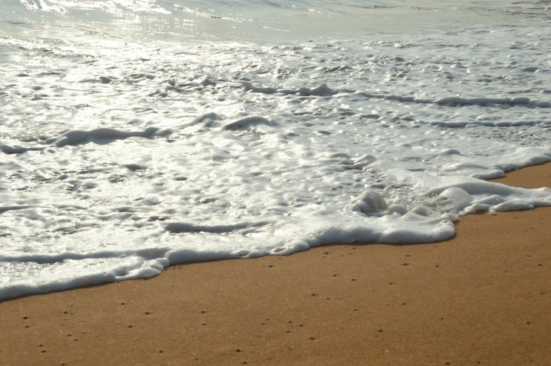 ocean waves washing over the sand with water around it