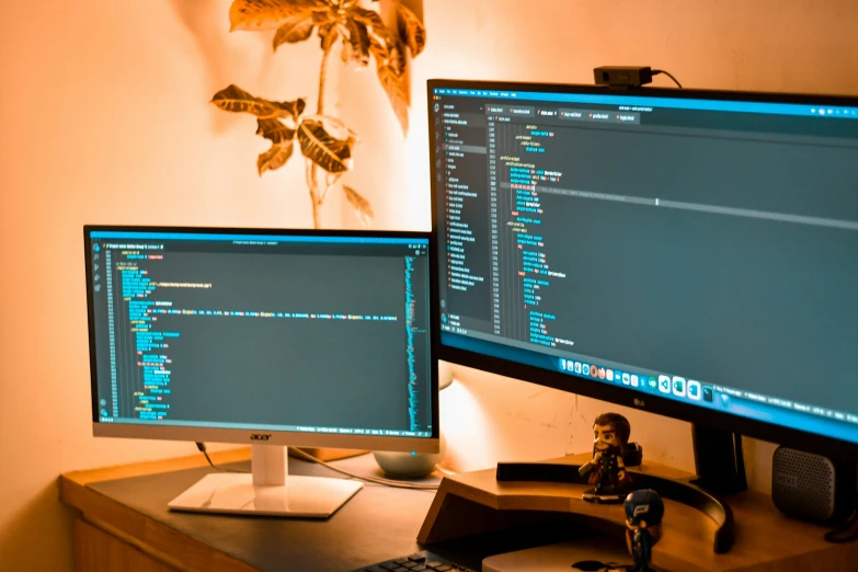 the computer desk has three large monitors and a laptop on it