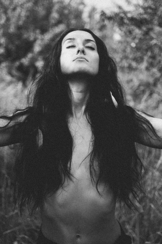 a  woman with long hair standing in a field