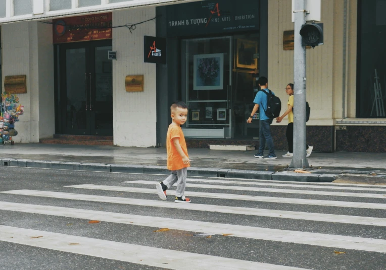 a  with glasses crosses the street as a man walks across the crosswalk