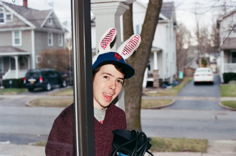 a boy with an easter egg hat on and gloves on