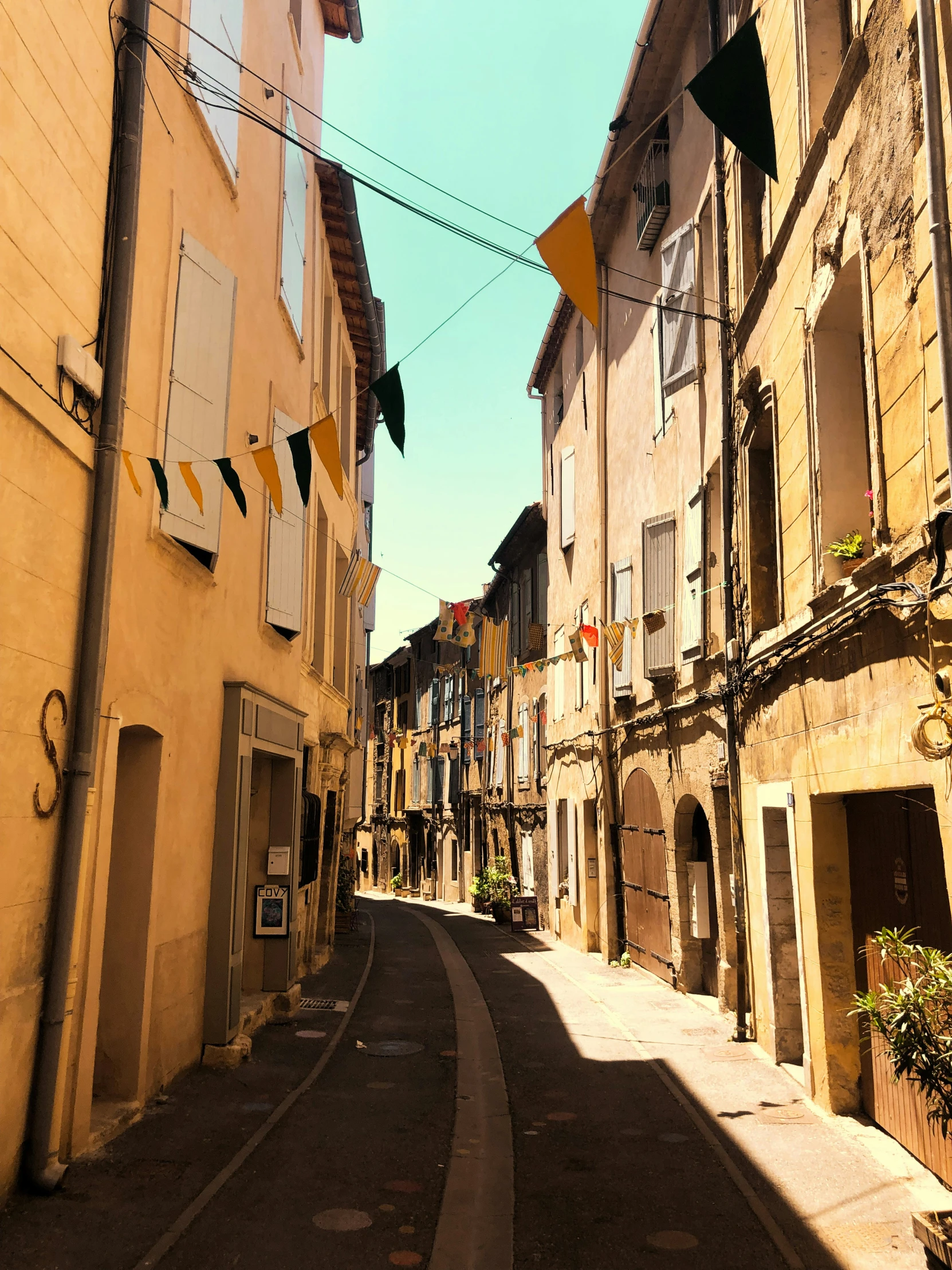 alley with yellow brick building and clothes hanging on wires