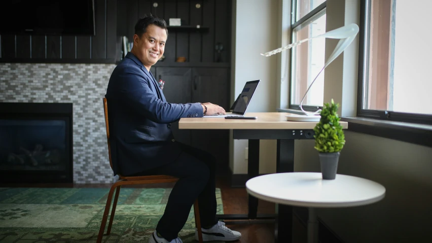 an image of man in business attire working on his laptop