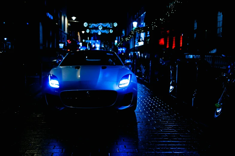 a car is parked along the street in the dark